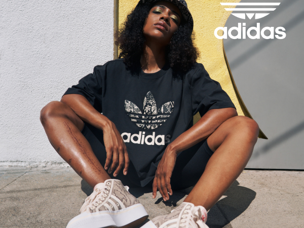 Image of a woman posing and wearing adidas Originals.