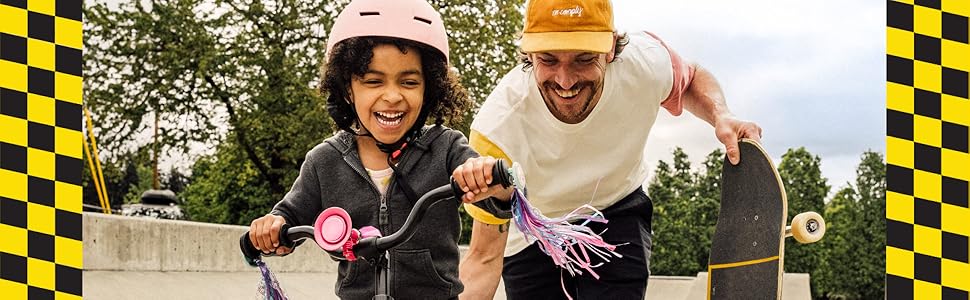 A father and daughter ride bikes together at a skate park.